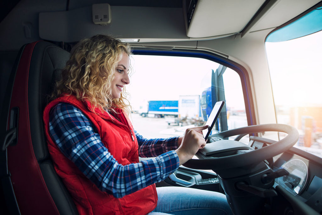Female trucker checking load boards on her tablet